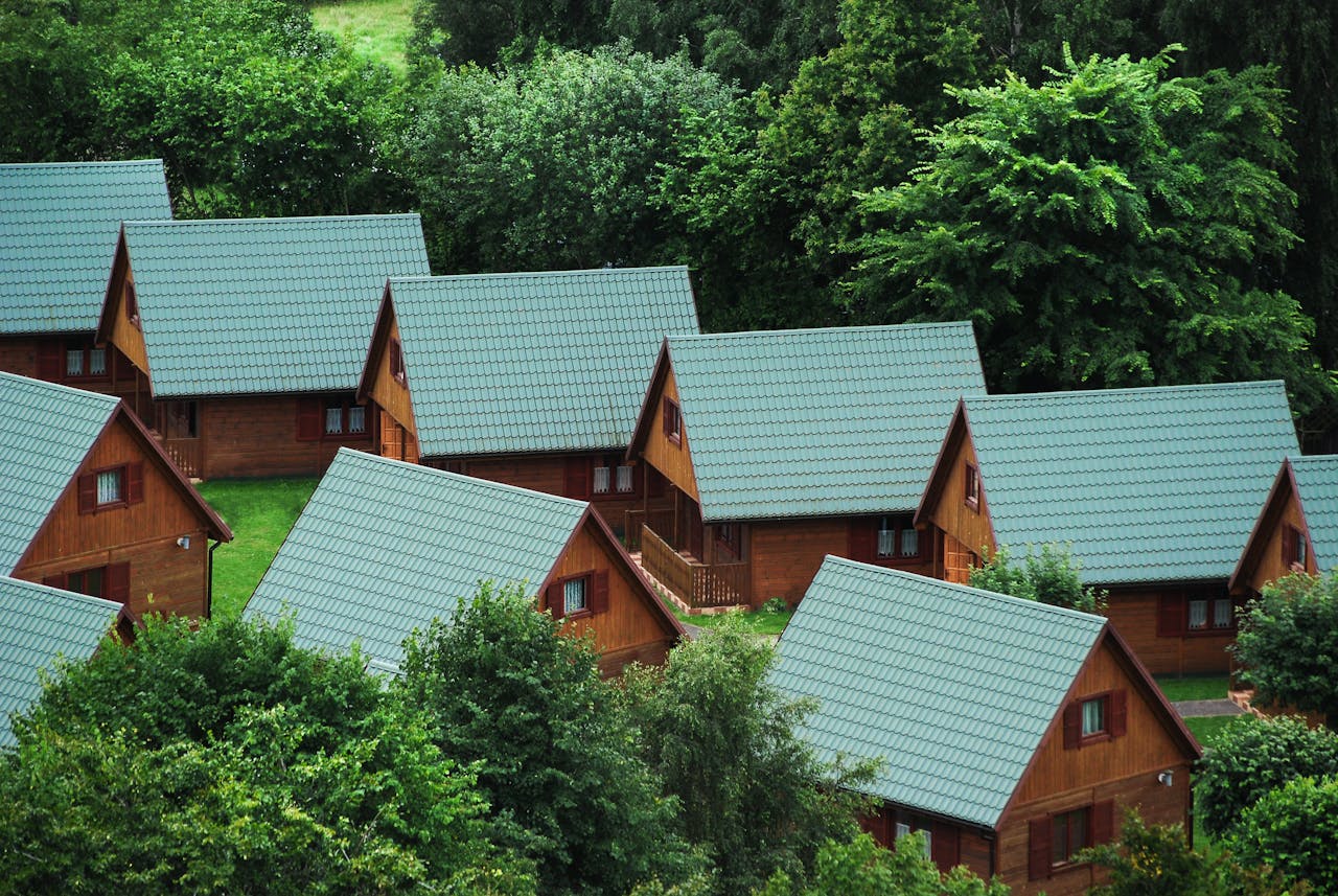 Picturesque wooden cabins nestled among trees, showcasing rustic architecture and serene nature.